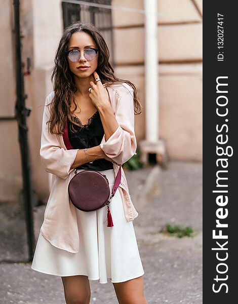 Girl posing for the camera with a female bag