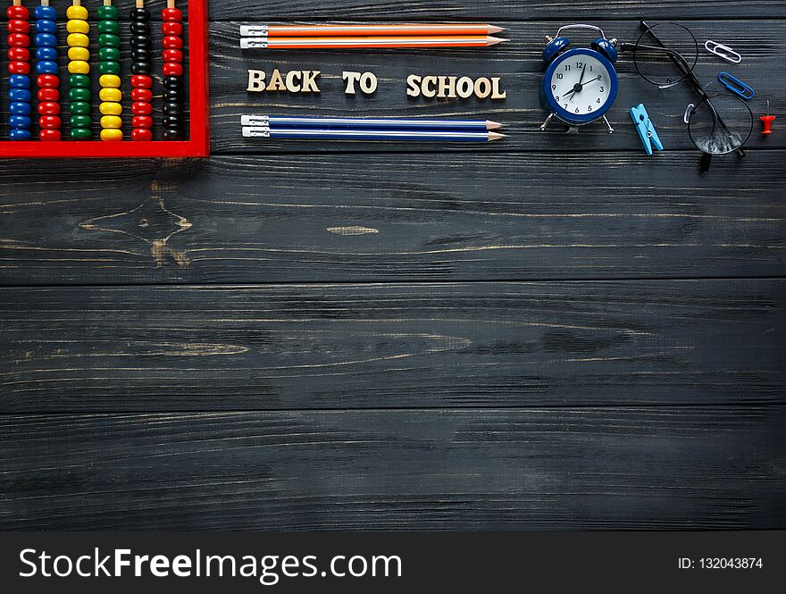 Back to school, education concept. set of stationery on the grey wooden background. scores, round glasses, pencils