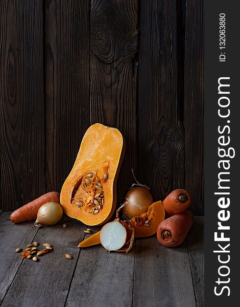 Pumpkin, onion and carrot on a wooden background, vegetables for