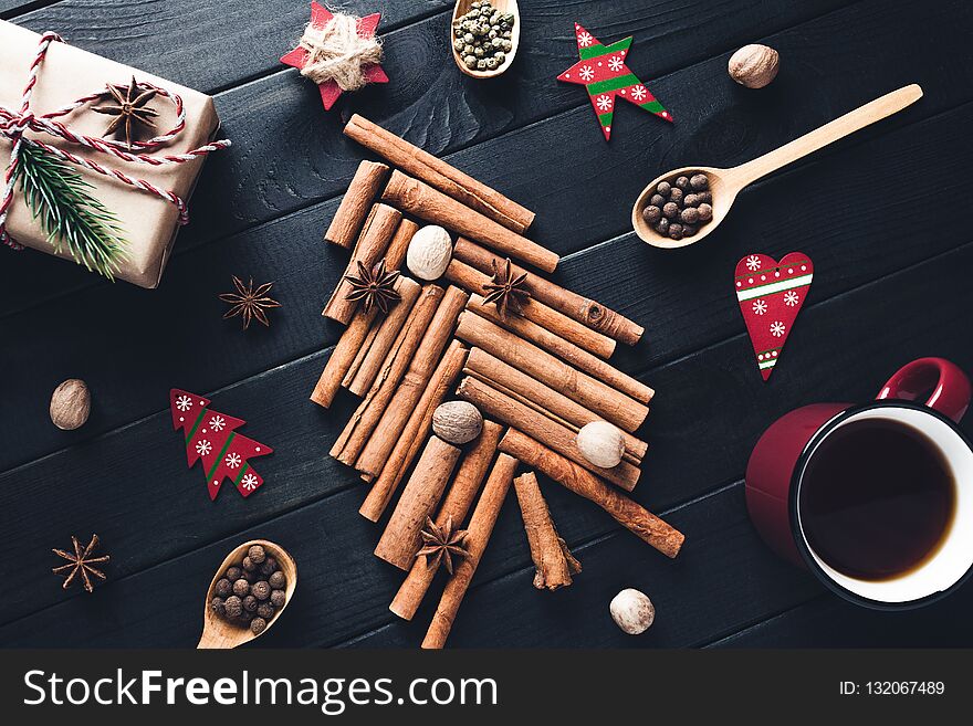 Christmas Tree Made Of Cinnamon, Star Anise, Spices And Nutmeg With Decorations On Dark Background