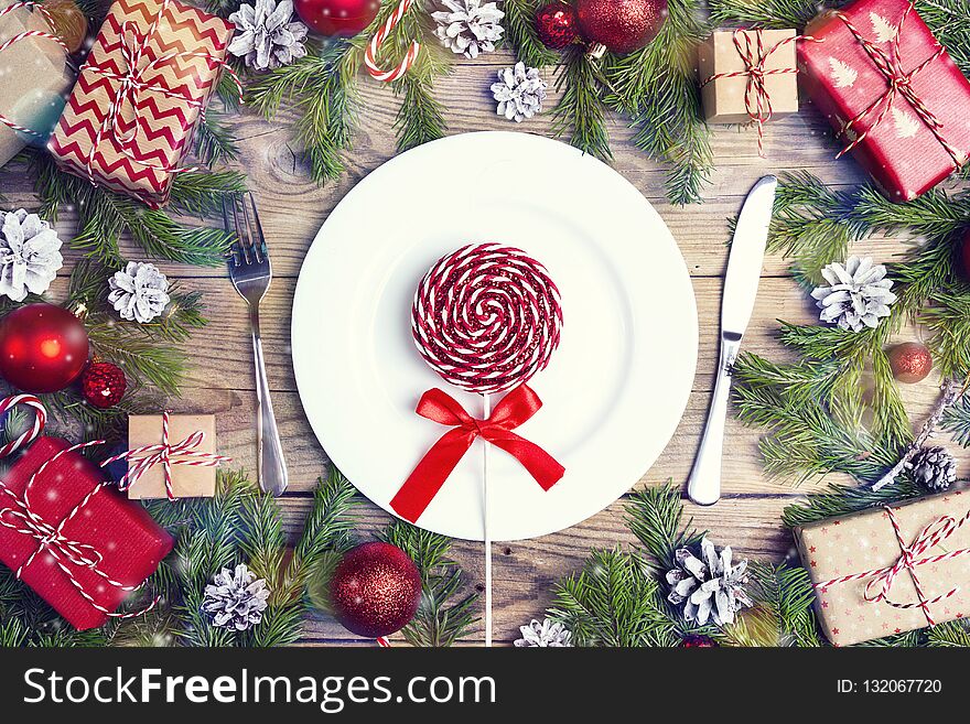 Festive table setting with cutlery, fir branches and Christmas decorations on wooden table. Top view. Christmas tableware