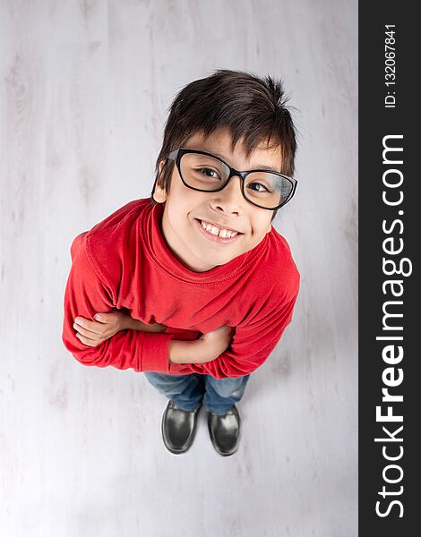 Schoolboy In A Red Shirt And Glasses And With Arms Crossed Smile