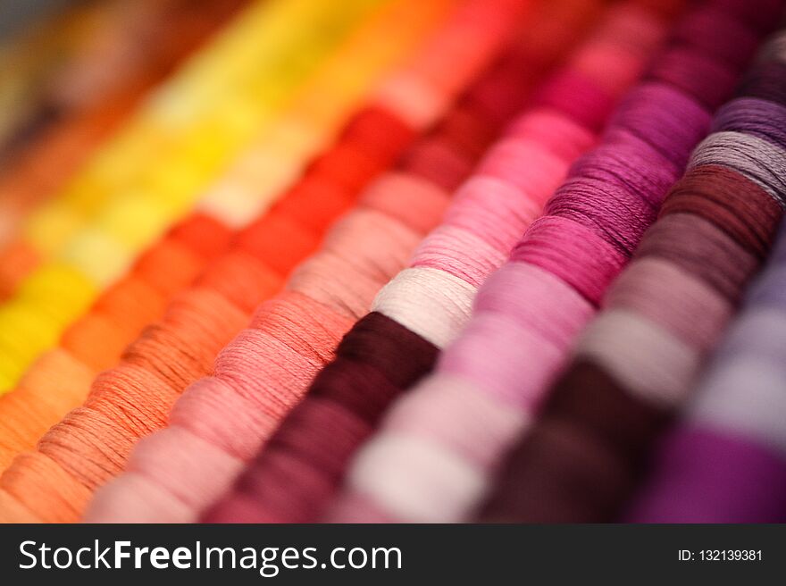 Multicolor sewing threads background. Shallow depth of field