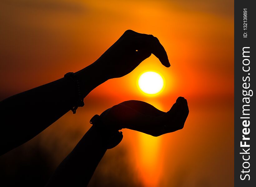 Sun silhouette at sunset centered on two hand bringing peace to the viewer. Sun silhouette at sunset centered on two hand bringing peace to the viewer