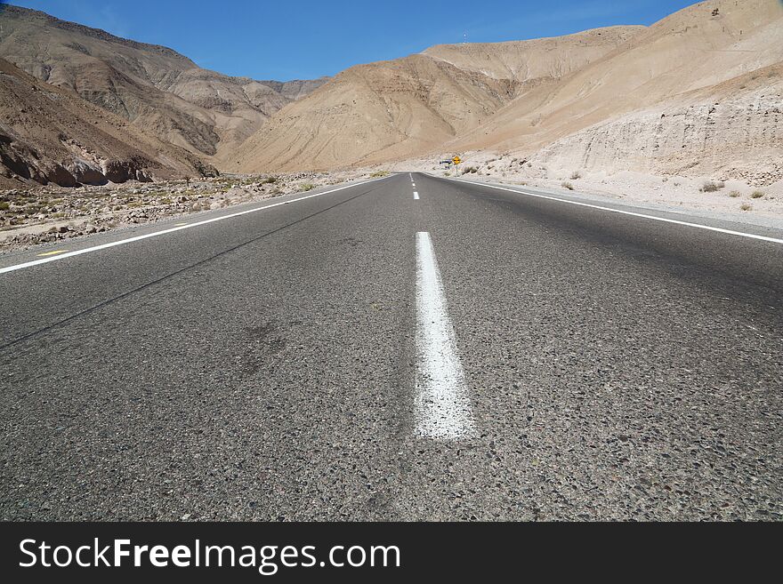 Empty and straight road in a totally arid environment of chilean Atacama desert. Empty and straight road in a totally arid environment of chilean Atacama desert