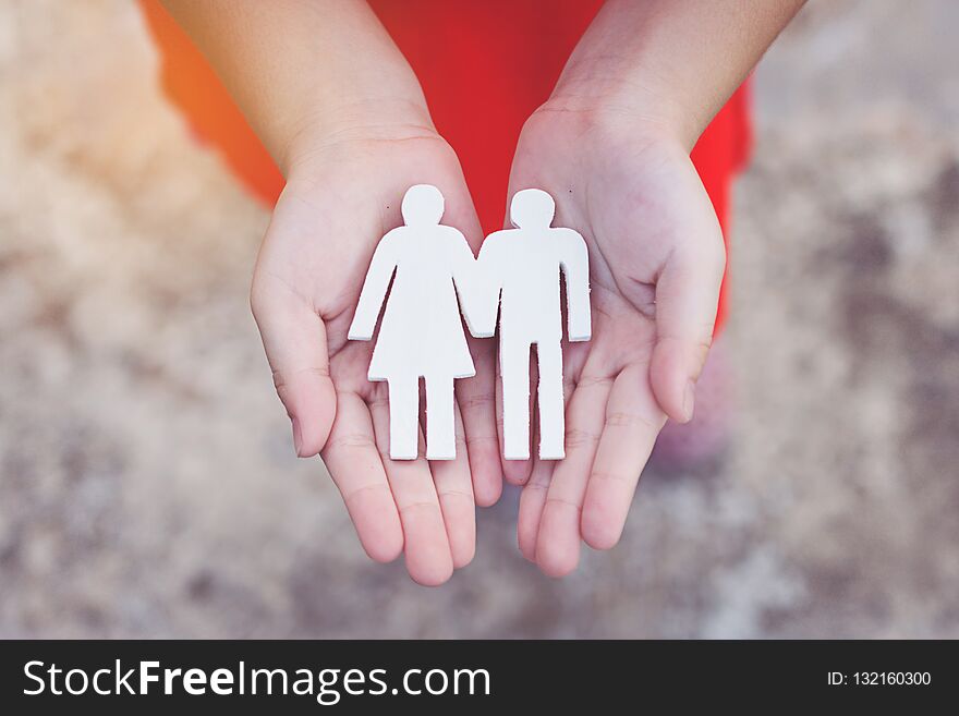 Children hands holding small model family , concept family.