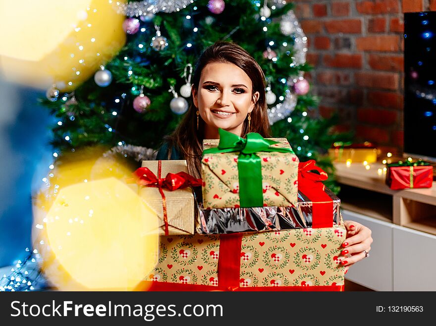 Happy young woman holding Christmas present. Woman at Christmas. Christmas surprise