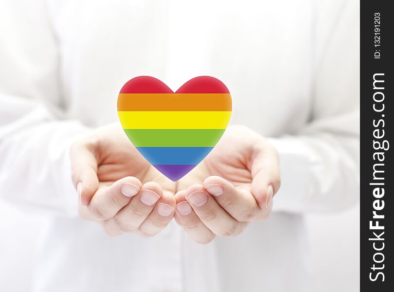 LGBT rainbow heart symbol of love in man& x27;s hands. LGBT rainbow heart symbol of love in man& x27;s hands