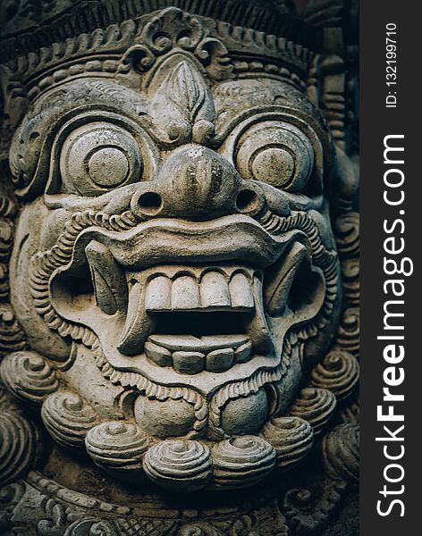 Closeup portrait of stone traditional sculpture art form incorporated into temples, which demonstrate the influences of Hindu Buddhist culture. Bali, Indonesia. Closeup portrait of stone traditional sculpture art form incorporated into temples, which demonstrate the influences of Hindu Buddhist culture. Bali, Indonesia