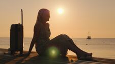 Romantic Woman With Luggage Looking At The Ship Far Into The Sea. At Sunrise Stock Image Romantic Woman With Luggage Looking At The Ship Far Into The Sea. At Sunrise Stock Image