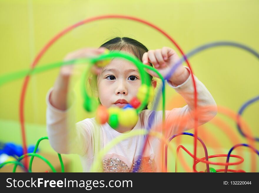 Close-up Asian child girl playing educational toy for brain development at kids room