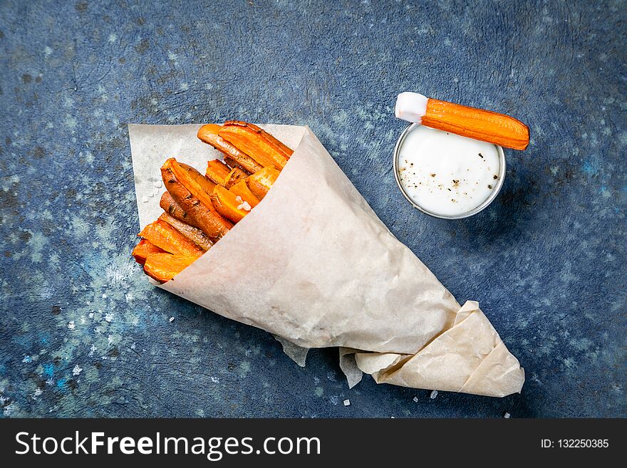 Healthy fries alternative - carrot fries, chips, wood background, copy space