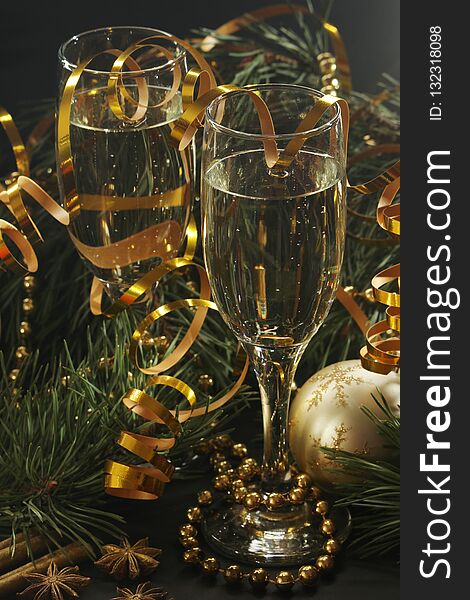 Two glasses full of champagne and pine trees with New Year decoration. Two glasses full of champagne and pine trees with New Year decoration