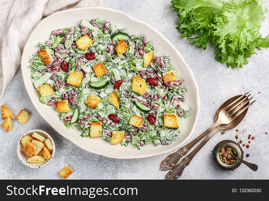 Delicious healthy salad of kidney beans, lettuce, cucumber with bread croutons