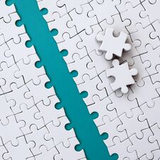 The Blue Path Is Laid On The Platform Of A White Folded Jigsaw Puzzle. The Missing Elements Of The Puzzle Are Stacked Nearby. Royalty Free Stock Images