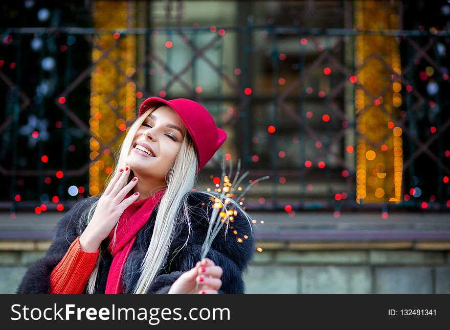 Adorable blonde girl celebrating New Year with sparklers at the