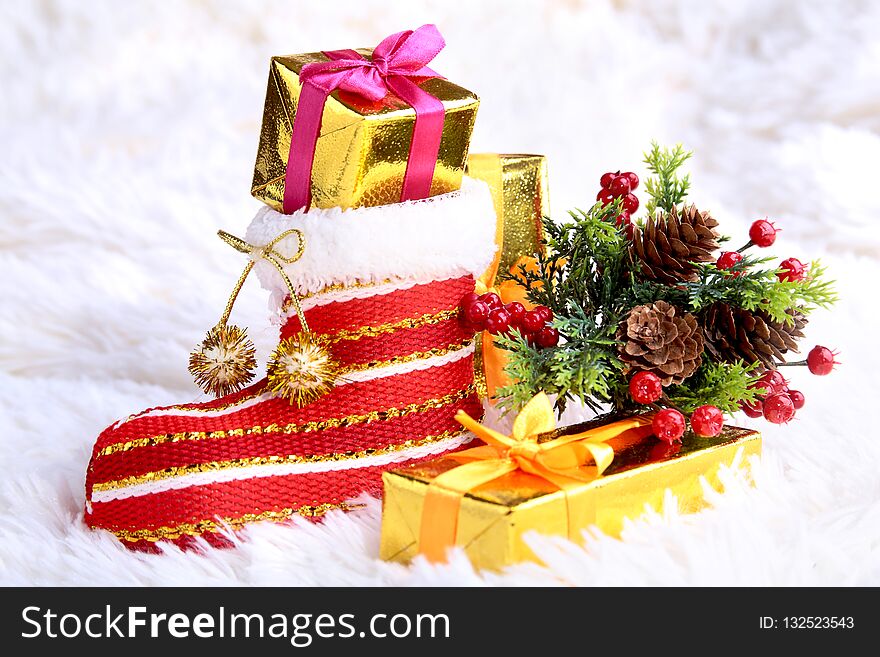 Merry Christmas composition. Santa`s shoe with gift boxes on billowy feathers with snow and snowflakes. Happy holidays.