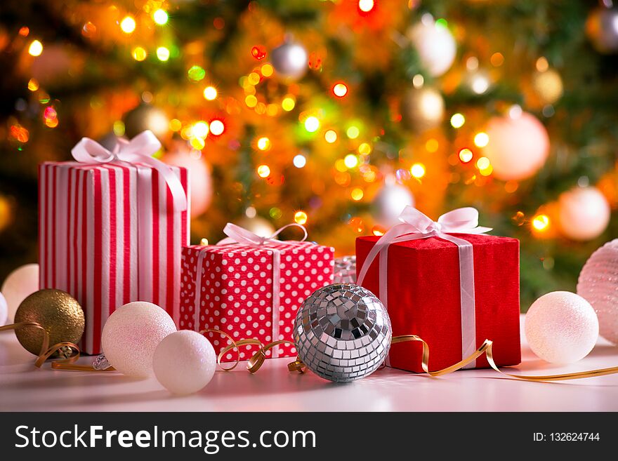 Christmas presents and balls against the backdrop of a festive Christmas tree