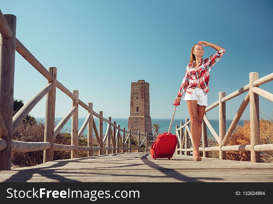 Beautiful woman carrying suitcase while walking up on bridge. Beautiful woman carrying suitcase while walking up on bridge