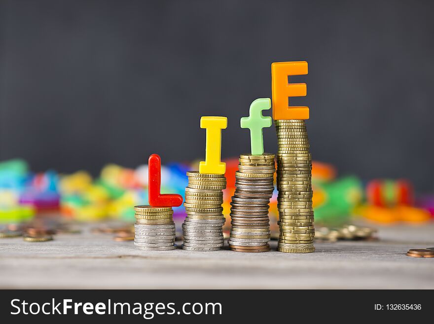 Life cost or cost of living concept with colourful letters on ascending piles of money