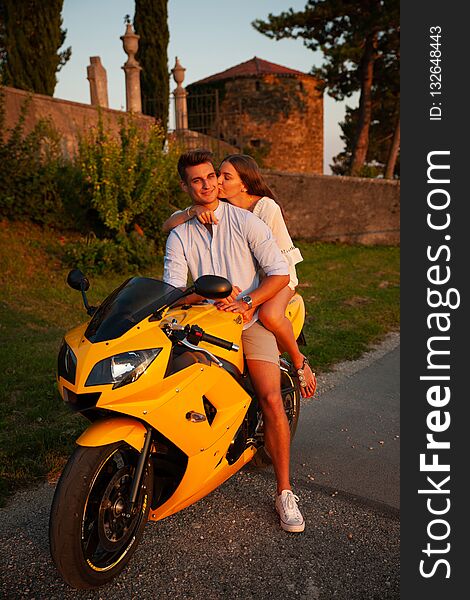 Young couple on a motor bike on a late summer afternoon .