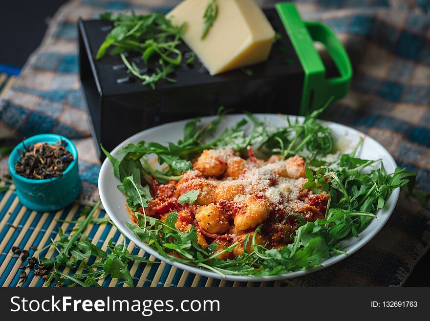 Gnocchi in plate with arugula, cheese and spices. Gnocchi in plate with arugula, cheese and spices