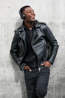 Smiling Black Man In Leather Jacket Listening To Music With Headphones Royalty Free Stock Photo