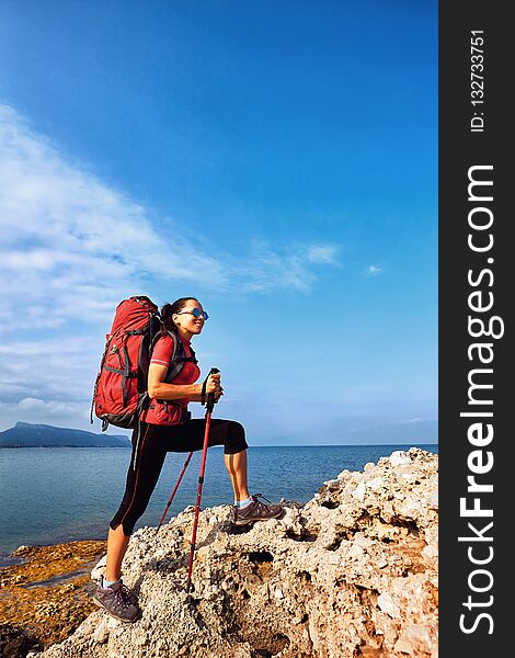 Adventure trek along the coast with a backpack in the summer