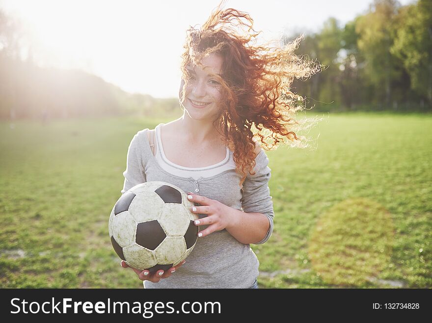 Young Redhead Girl In Casual Player In Soccer Stadium At Sunset