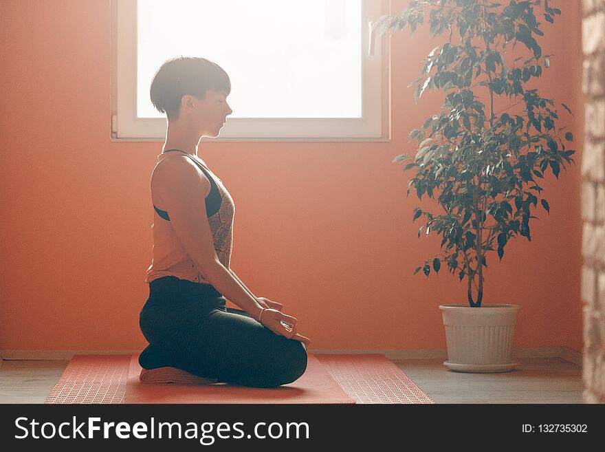 Side view of woman doing yoga training at home
