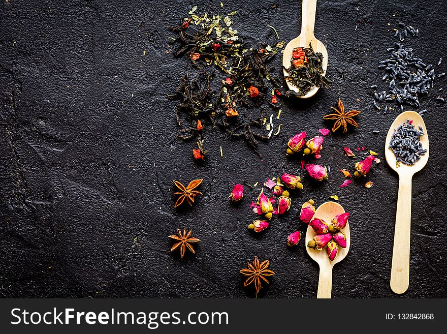 Herbs on spoons black stone background mock-up top view