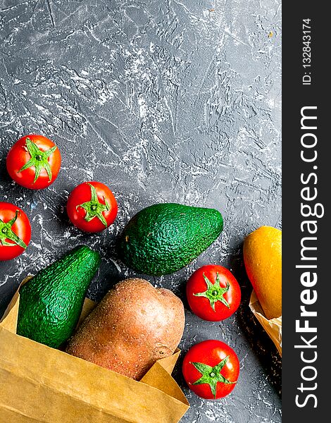 Store concept with vegetables and paper bag on gray table background top view mockup. Store concept with vegetables and paper bag on gray table background top view mockup