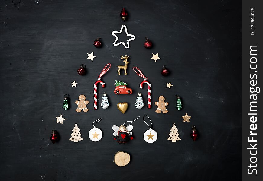 Christmas tree shaped out of different Christmas deco items, on black chalkboard