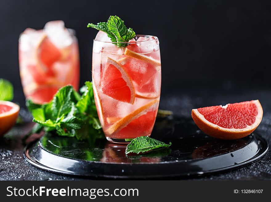 Fresh grapefruit cocktail. Fresh summer cocktail with grapefruit and ice cubes. Glass of grapefruit mojito.