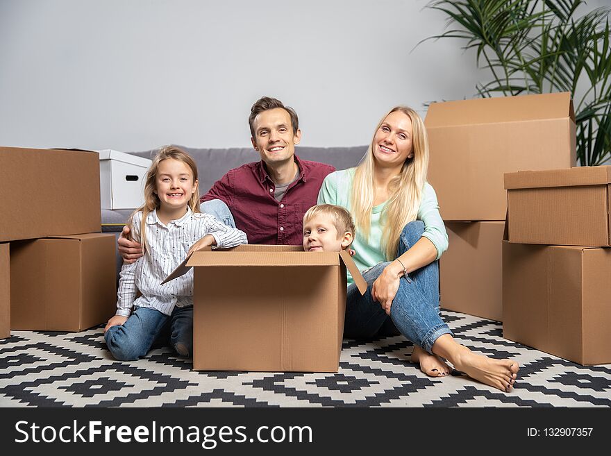 Image Of Happy Parents And Children Among Cardboard Boxes In New Apartment