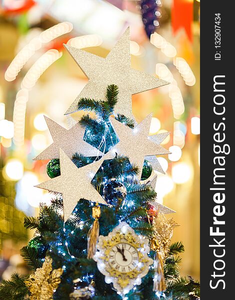 Photo of decorated Christmas spruce with clock, blue balls in store, defocused background. Photo of decorated Christmas spruce with clock, blue balls in store, defocused background.