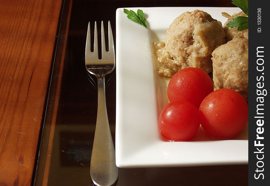 Meatballs in onion sauce whit cherry tomatoes and a cup of white wine