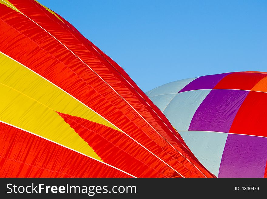 Beautiful hot air balloon preparing for launch against dark blue sky