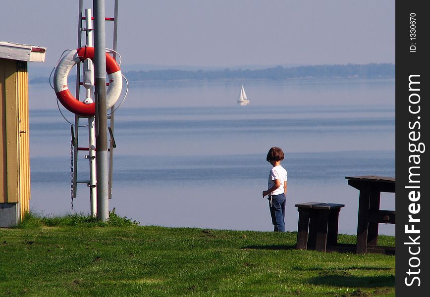 Litte girl is watching on the lake. Litte girl is watching on the lake