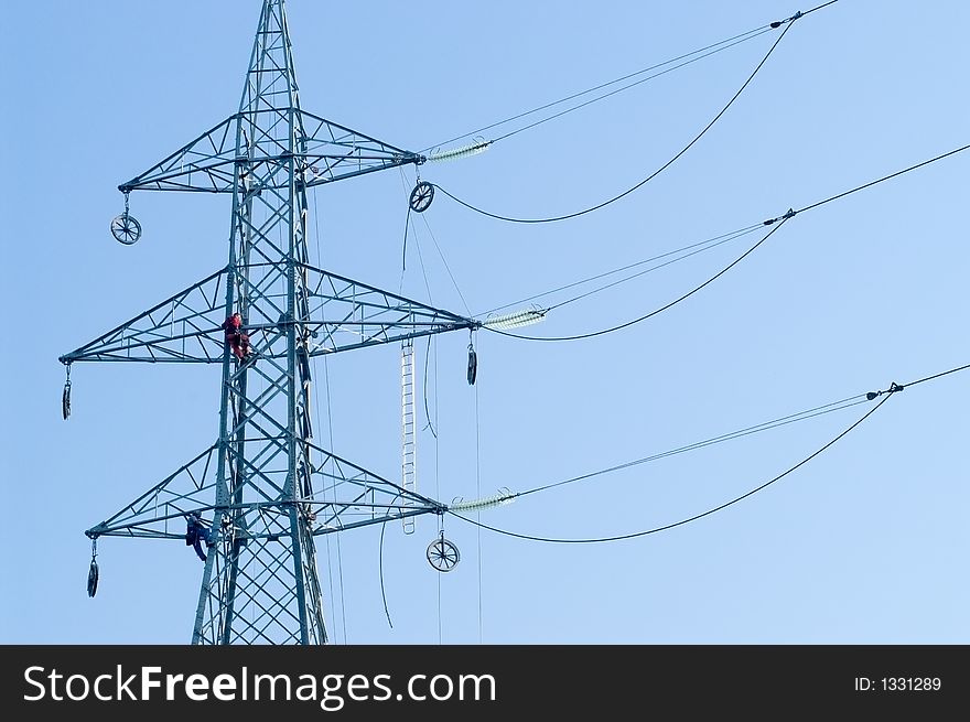 Two workers connecting wires on electrical pylon. Two workers connecting wires on electrical pylon