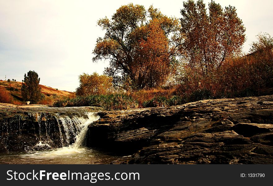 A flowing stream with rocks and trees in Colorado. A flowing stream with rocks and trees in Colorado.