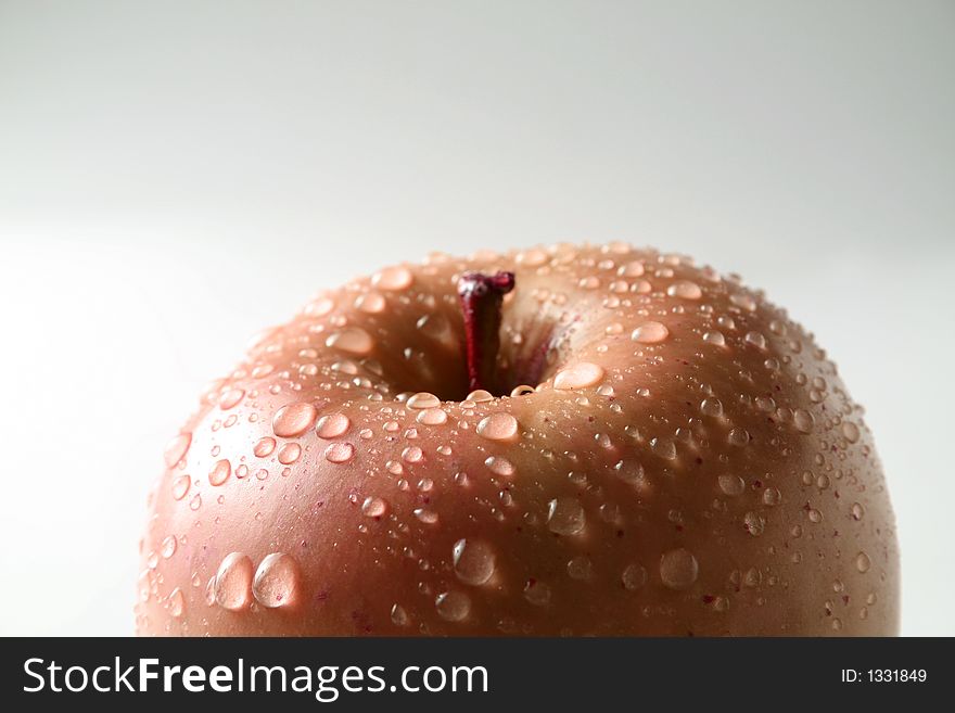 Juicy fresh apples separately from a background with drops of water on a leather