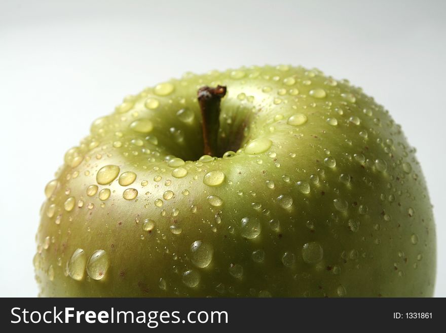 Juicy fresh apples separately from a background with drops of water on a leather