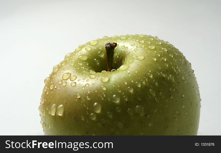 Juicy fresh apples separately from a background with drops of water on a leather