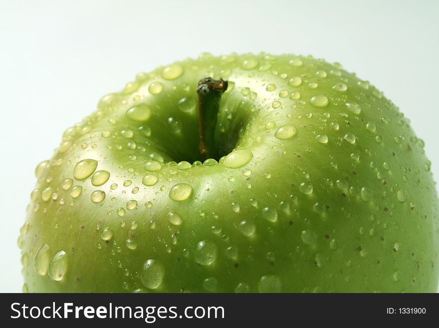 Juicy fresh apples separately from a background with drops of water on a leather