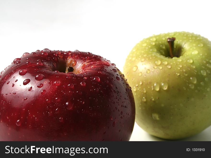 Juicy fresh apples separately from a background with drops of water on a leather