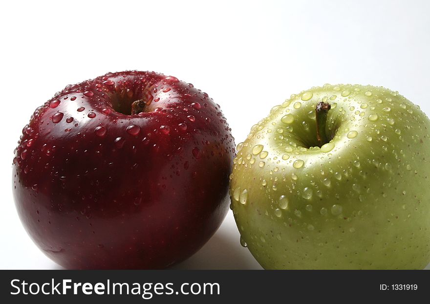 Juicy fresh apples separately from a background with drops of water on a leather