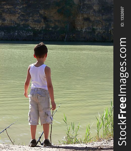 A boy fishing on the banks of a river