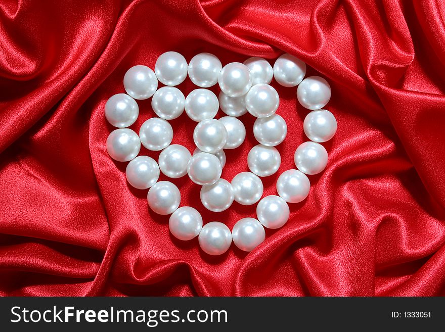 Pearls heart on red background