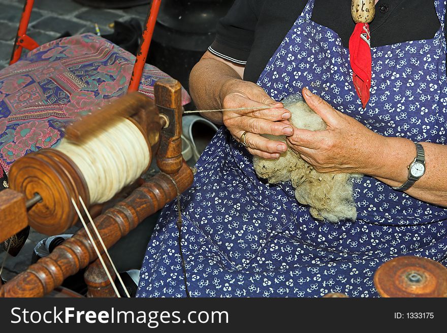 Woman spinning wool with a spinning wheel